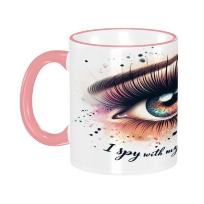A pink-handled ceramic mug displays an eye illustration with the text "I Spy2." A pink-handled ceramic mug displays an eye illustration with the text "I Spy2." A pink-handled ceramic mug displays an eye illustration with the text "I Spy2."